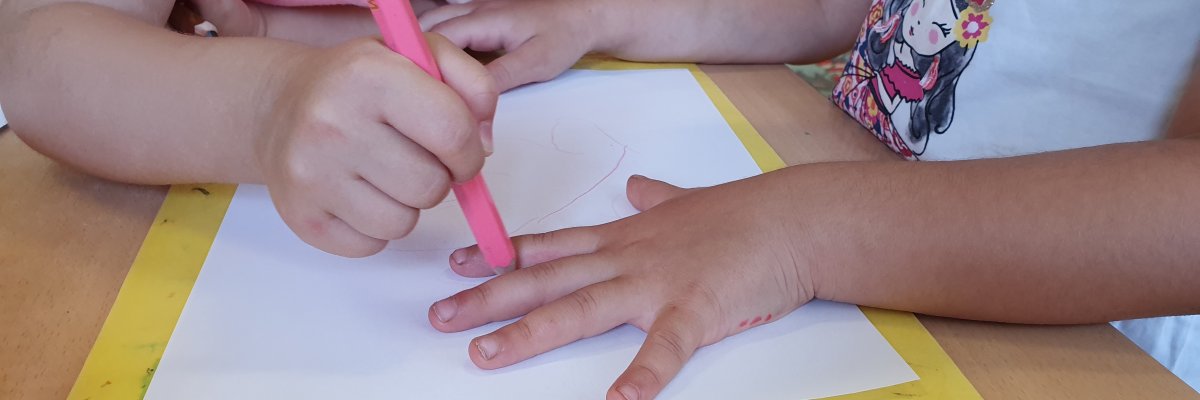 Kinder malen ihre Hände auf Papier