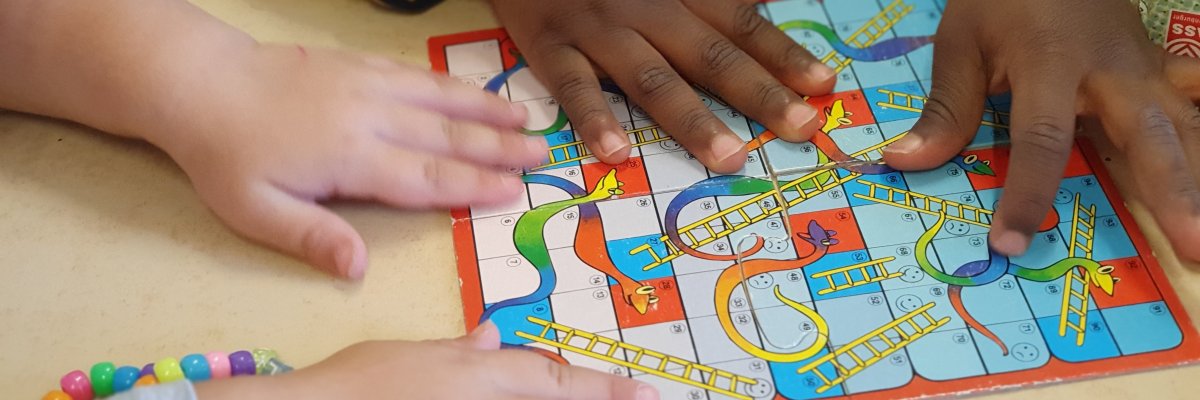 Kinder spielen das Leiterspiel